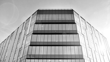 Modern cam ve alüminyum ofis duvarı açık havada güneş ışınları düşüyor. Siyah ve beyaz.