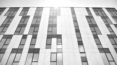 Modern cam ve alüminyum ofis duvarı açık havada güneş ışınları düşüyor. Siyah ve beyaz.