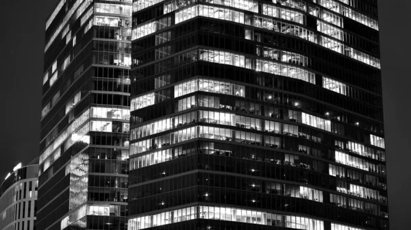 令人惊奇的夜景晚上是写字楼 正面是玻璃和灯 光芒四射的现代摩天大楼 傍晚时分 摩天大楼的灯光明亮的窗户 黑人和白人 — 图库照片