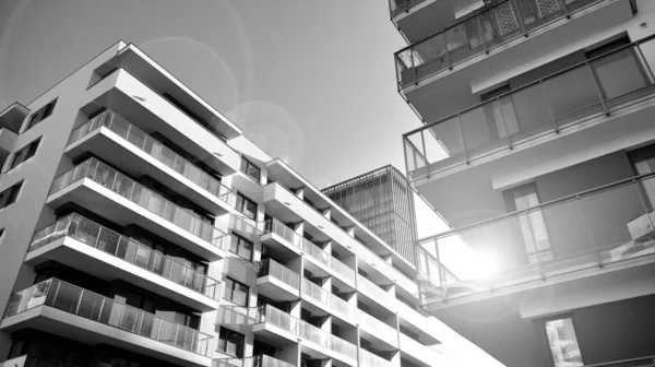 Modern lüks konut dairesi. Güneşli bir günde modern apartman binası. Mavi gökyüzü olan beyaz bir apartman. Modern bir apartmanın ön cephesi. Siyah ve beyaz.