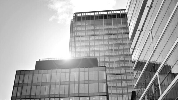 View of an modern apartment building standing next to a new modern office building with a glass facade. Black and white.
