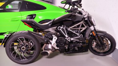 Varşova, Polonya. 8 Şubat 2022. Yeşil Porsche 911 GT3 RS spor araba ve siyah Ducati XDiavel S motosikleti yeraltı garajında park halinde.. 