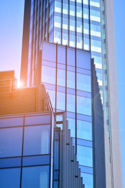 Modern şehrin iş bölgesindeki bina parçaları. Şehir merkezindeki yüksek katlı ofis binası. Tipik beton, cam ve çelikten modern mimari.