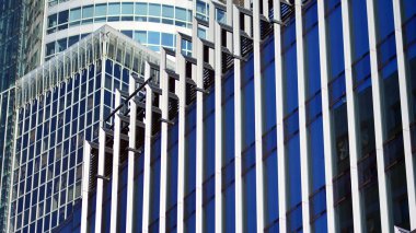 Modern şehrin iş bölgesindeki bina parçaları. Şehir merkezindeki yüksek katlı ofis binası. Tipik beton, cam ve çelikten modern mimari.