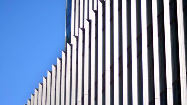 Modern şehrin iş bölgesindeki bina parçaları. Şehir merkezindeki yüksek katlı ofis binası. Tipik beton, cam ve çelikten modern mimari.