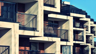 Soyut mimari, modern şehir geometrisinin bir parçası. Mavi gökyüzü olan güneşli bir günde modern apartman binası. Avrupa 'daki apartman binaları. Çapraz işlem fotoğraf filtresi.