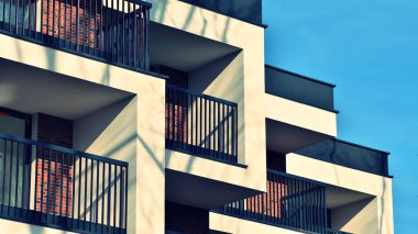 Soyut mimari, modern şehir geometrisinin bir parçası. Mavi gökyüzü olan güneşli bir günde modern apartman binası. Avrupa 'daki apartman binaları. Çapraz işlem fotoğraf filtresi.