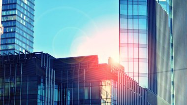 Modern şehrin iş bölgesindeki bina parçaları. Şehir merkezindeki yüksek katlı ofis binası. Tipik beton, cam ve çelikten modern mimari. Çapraz işlem fotoğraf filtresi.