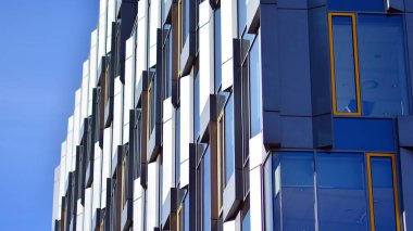 Şehir soyutu - ofis binasının pencereli duvarı. Şehirdeki modern iş binasının detaylı görüntüleri. Bir gökdelenin cam cephesine bakıyorum..