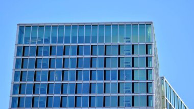 Şehir soyutu - ofis binasının pencereli duvarı. Şehirdeki modern iş binasının detaylı görüntüleri. Bir gökdelenin cam cephesine bakıyorum..