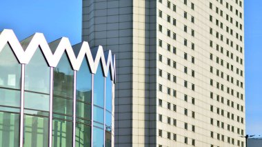 Şehir soyutu - ofis binasının pencereli duvarı. Şehirdeki modern iş binasının detaylı görüntüleri. Bir gökdelenin cam cephesine bakıyorum..