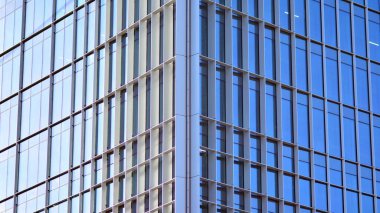 Şehir soyutu - ofis binasının pencereli duvarı. Şehirdeki modern iş binasının detaylı görüntüleri. Bir gökdelenin cam cephesine bakıyorum..