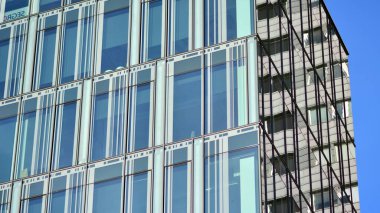 Şehir soyutu - ofis binasının pencereli duvarı. Şehirdeki modern iş binasının detaylı görüntüleri. Bir gökdelenin cam cephesine bakıyorum..