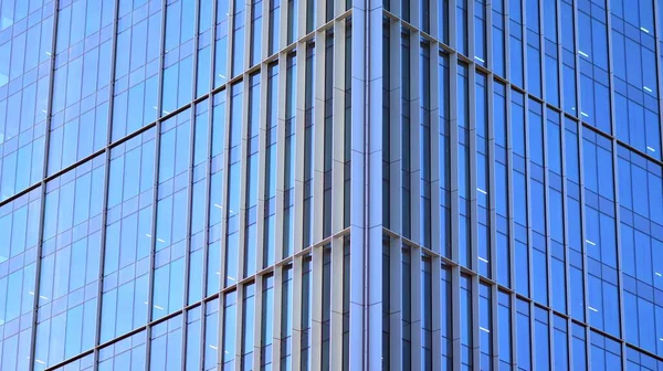 Şehir soyutu - ofis binasının pencereli duvarı. Şehirdeki modern iş binasının detaylı görüntüleri. Bir gökdelenin cam cephesine bakıyorum..