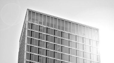 Şehir soyutu - ofis binasının pencereli duvarı. Şehirdeki modern iş binasının detaylı görüntüleri. Bir gökdelenin cam cephesine bakıyorum. Siyah beyaz filtre.