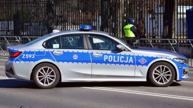 Varşova, Polonya. 10 Mart 2022. Polis arabasındaki sokakta bir polis. Polis işareti.