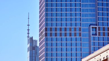 Şehir soyutu - ofis binasının pencereli duvarı. Şehirdeki modern iş binasının detaylı görüntüleri. Bir gökdelenin cam cephesine bakıyorum..