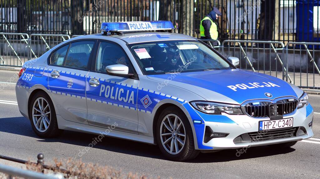 Warsaw, Poland. 10 March 2022. Policeman on a street in police car. Police sign.