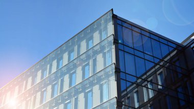 Çelik ve mavi camlara bakış açısı. Ticari modern geleceğin şehri. İşletme konsepti başarılı endüstriyel mimari. Binanın üzerine güneş ışığı düşüyor..