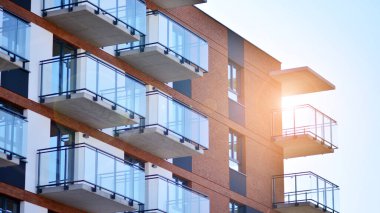 Güneşli bir günde modern Avrupa konut mimarisi. Yeni çok katlı konut binasının dışı. Tüketiciler için konut satışı ve kiralama kavramı. Modern pencere ve balkonlar.