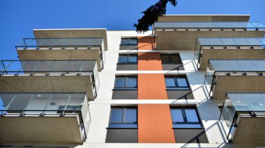 Güneşli bir günde modern Avrupa konut mimarisi. Yeni çok katlı konut binasının dışı. Tüketiciler için konut satışı ve kiralama kavramı. Modern pencere ve balkonlar.