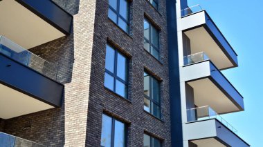 Güneşli bir günde modern Avrupa konut mimarisi. Yeni çok katlı konut binasının dışı. Tüketiciler için konut satışı ve kiralama kavramı. Modern pencere ve balkonlar.