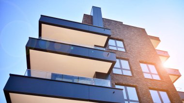 Güneşli bir günde modern Avrupa konut mimarisi. Yeni çok katlı konut binasının dışı. Tüketiciler için konut satışı ve kiralama kavramı. Modern pencere ve balkonlar.