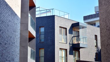 Güneşli bir günde modern Avrupa konut mimarisi. Yeni çok katlı konut binasının dışı. Tüketiciler için konut satışı ve kiralama kavramı. Modern pencere ve balkonlar.