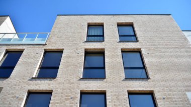 Güneşli bir günde modern Avrupa konut mimarisi. Yeni çok katlı konut binasının dışı. Tüketiciler için konut satışı ve kiralama kavramı. Modern pencere ve balkonlar.