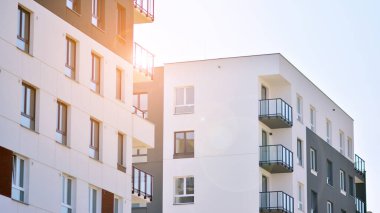 Güneşli bir günde modern Avrupa konut mimarisi. Yeni çok katlı konut binasının dışı. Tüketiciler için konut satışı ve kiralama kavramı. Modern pencere ve balkonlar.
