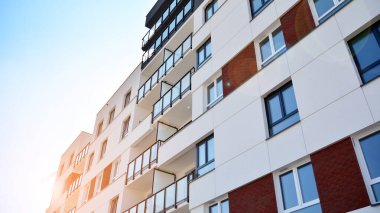 Güneşli bir günde modern Avrupa konut mimarisi. Yeni çok katlı konut binasının dışı. Tüketiciler için konut satışı ve kiralama kavramı. Modern pencere ve balkonlar.