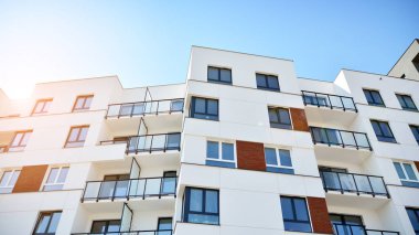 Güneşli bir günde modern Avrupa konut mimarisi. Yeni çok katlı konut binasının dışı. Tüketiciler için konut satışı ve kiralama kavramı. Modern pencere ve balkonlar.