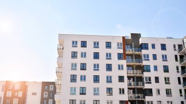 Güneşli bir günde modern Avrupa konut mimarisi. Yeni çok katlı konut binasının dışı. Tüketiciler için konut satışı ve kiralama kavramı. Modern pencere ve balkonlar.