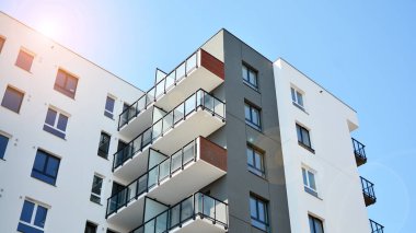 Güneşli bir günde modern Avrupa konut mimarisi. Yeni çok katlı konut binasının dışı. Tüketiciler için konut satışı ve kiralama kavramı. Modern pencere ve balkonlar.