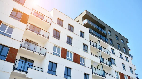 Güneşli bir günde modern Avrupa konut mimarisi. Yeni çok katlı konut binasının dışı. Tüketiciler için konut satışı ve kiralama kavramı. Modern pencere ve balkonlar.
