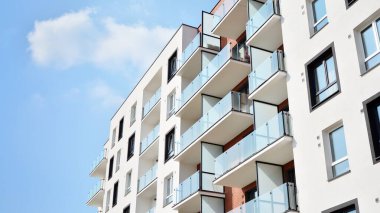 Güneşli bir günde modern Avrupa konut mimarisi. Yeni çok katlı konut binasının dışı. Tüketiciler için konut satışı ve kiralama kavramı. Modern pencere ve balkonlar.