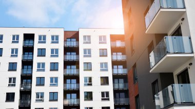 Güneşli bir günde modern Avrupa konut mimarisi. Yeni çok katlı konut binasının dışı. Tüketiciler için konut satışı ve kiralama kavramı. Modern pencere ve balkonlar.