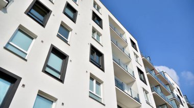 Güneşli bir günde modern Avrupa konut mimarisi. Yeni çok katlı konut binasının dışı. Tüketiciler için konut satışı ve kiralama kavramı. Modern pencere ve balkonlar.