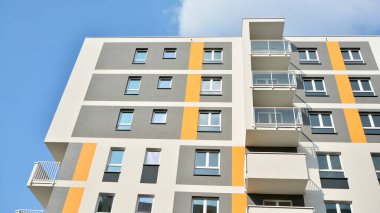 Güneşli bir günde modern Avrupa konut mimarisi. Yeni çok katlı konut binasının dışı. Tüketiciler için konut satışı ve kiralama kavramı. Modern pencere ve balkonlar.