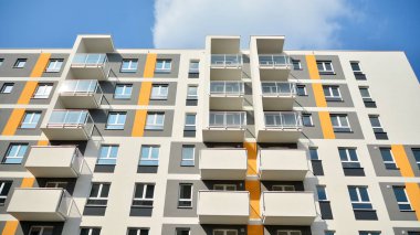 Güneşli bir günde modern Avrupa konut mimarisi. Yeni çok katlı konut binasının dışı. Tüketiciler için konut satışı ve kiralama kavramı. Modern pencere ve balkonlar.