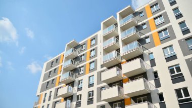 Güneşli bir günde modern Avrupa konut mimarisi. Yeni çok katlı konut binasının dışı. Tüketiciler için konut satışı ve kiralama kavramı. Modern pencere ve balkonlar.