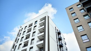 Güneşli bir günde modern Avrupa konut mimarisi. Yeni çok katlı konut binasının dışı. Tüketiciler için konut satışı ve kiralama kavramı. Modern pencere ve balkonlar.