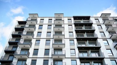 Güneşli bir günde modern Avrupa konut mimarisi. Yeni çok katlı konut binasının dışı. Tüketiciler için konut satışı ve kiralama kavramı. Modern pencere ve balkonlar.
