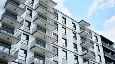 Güneşli bir günde modern Avrupa konut mimarisi. Yeni çok katlı konut binasının dışı. Tüketiciler için konut satışı ve kiralama kavramı. Modern pencere ve balkonlar.