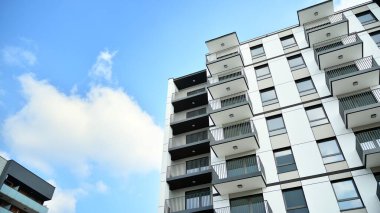 Güneşli bir günde modern Avrupa konut mimarisi. Yeni çok katlı konut binasının dışı. Tüketiciler için konut satışı ve kiralama kavramı. Modern pencere ve balkonlar.