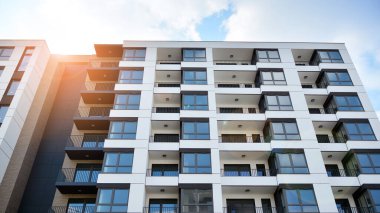 Güneşli bir günde modern Avrupa konut mimarisi. Yeni çok katlı konut binasının dışı. Tüketiciler için konut satışı ve kiralama kavramı. Modern pencere ve balkonlar.