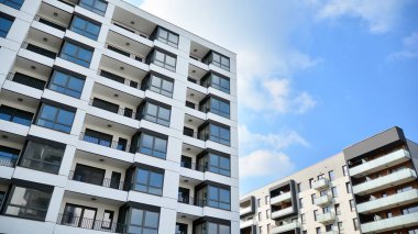 Güneşli bir günde modern Avrupa konut mimarisi. Yeni çok katlı konut binasının dışı. Tüketiciler için konut satışı ve kiralama kavramı. Modern pencere ve balkonlar.