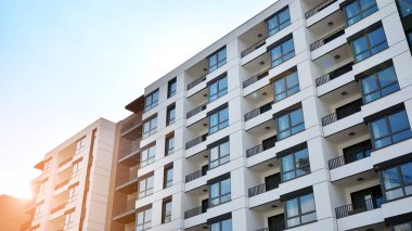 Modern european residential architecture on a sunny day. Exterior of new multi-story residential building. Concept of sale and rental of apartments for  consumers .Modern windows and balconies. clipart