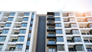 Güneşli bir günde modern Avrupa konut mimarisi. Yeni çok katlı konut binasının dışı. Tüketiciler için konut satışı ve kiralama kavramı. Modern pencere ve balkonlar.