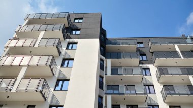 Güneşli bir günde modern Avrupa konut mimarisi. Yeni çok katlı konut binasının dışı. Tüketiciler için konut satışı ve kiralama kavramı. Modern pencere ve balkonlar.